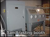 The sandblasting booth with the fire hose sand blaster.